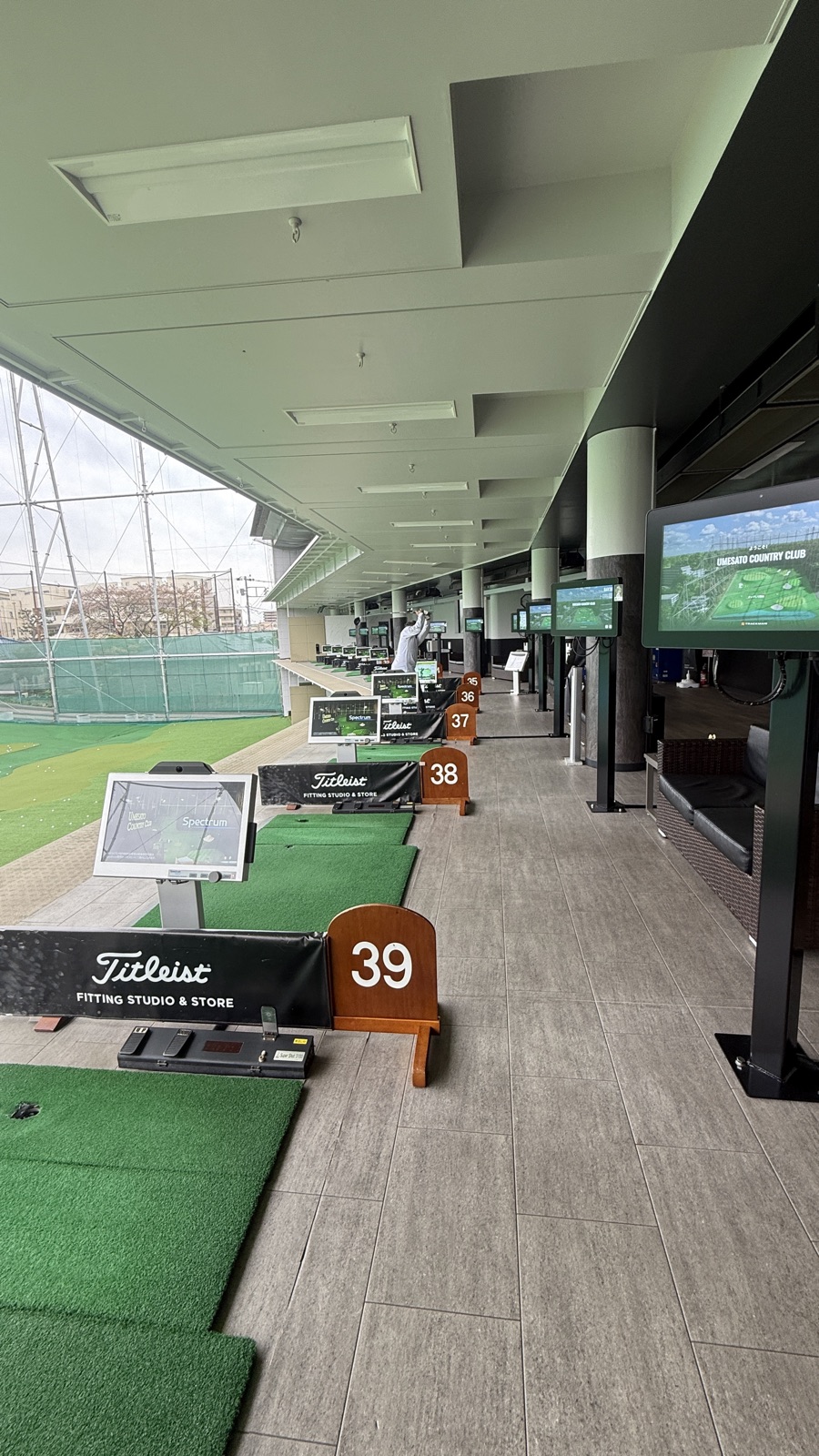 梅里カントリークラブの打席通路。Titleist案内板と番号札が並ぶ